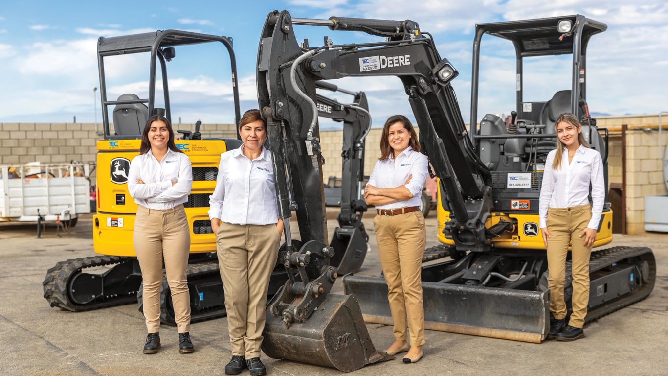 The Equipment Connection team standing in front of John Deere construction machinery.