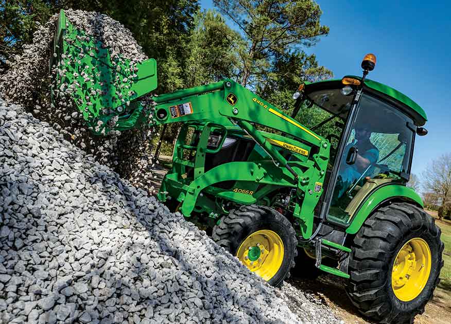 John Deere 4066R Compact Tractor picking up rocks with the 440R bucket attachment