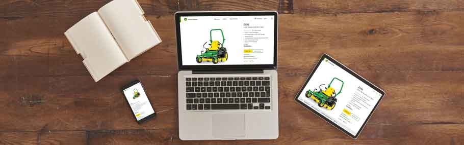 A computer, tablet, and mobile phone on a wooden table with the John Deere Z515E ZTrak zero turn mower on the screens