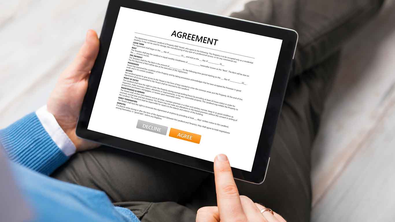 Man holding a tablet with a financial agreement on the screen