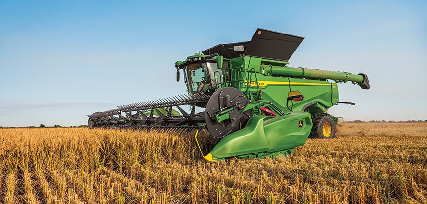 John Deere combine harvesting corn field
