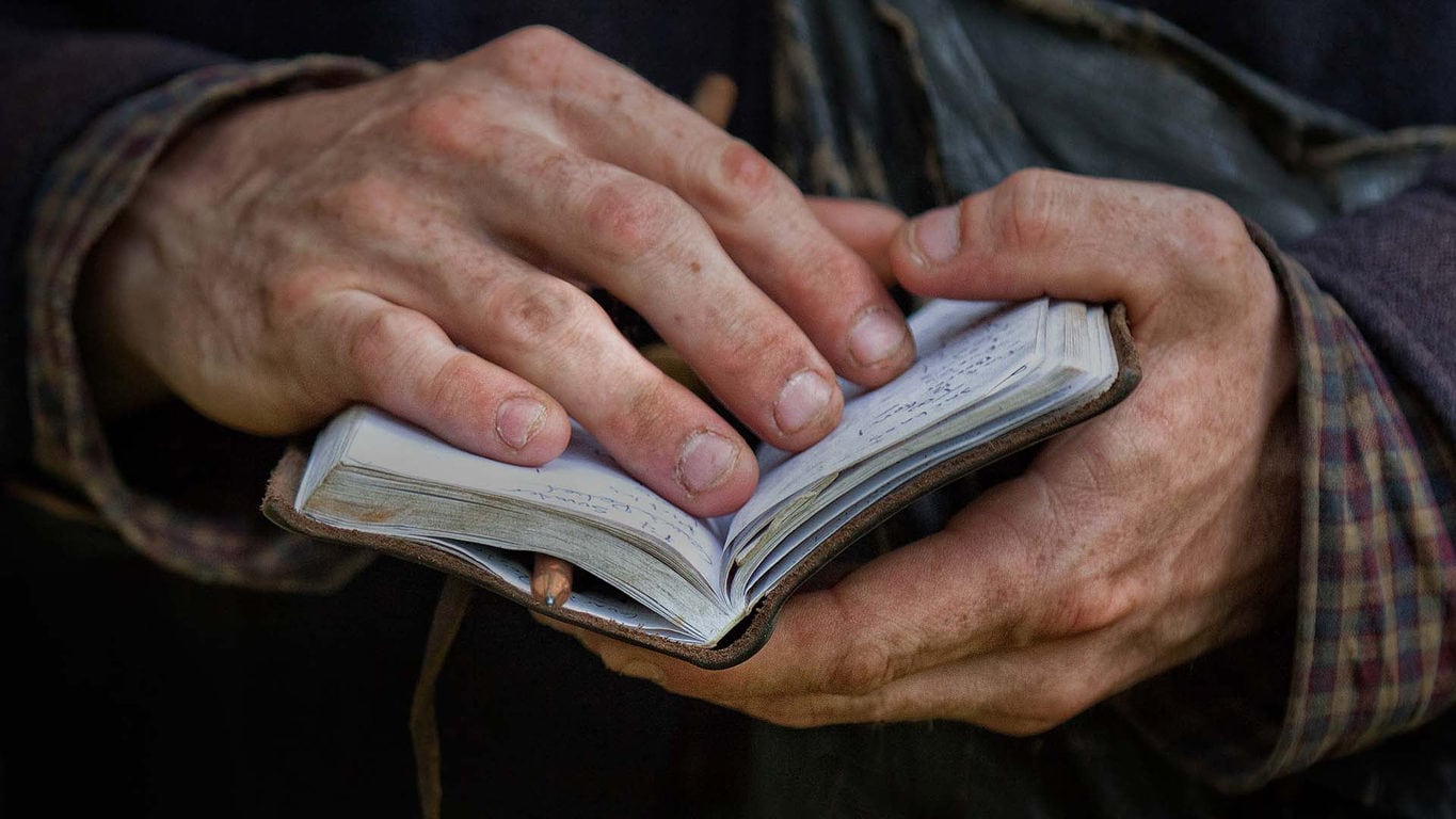Close up on dirty hands holding notebook
